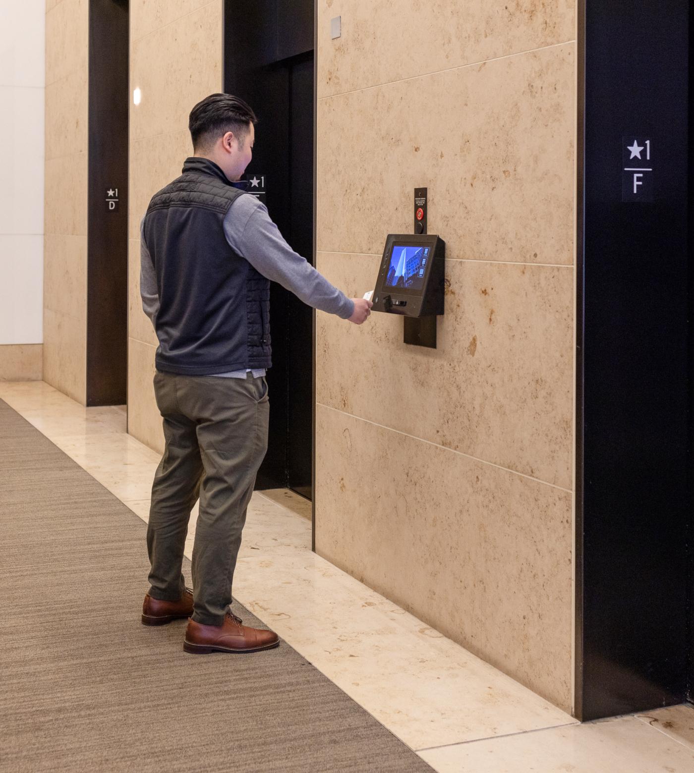 A man interacting with the newly renovated elevator display.