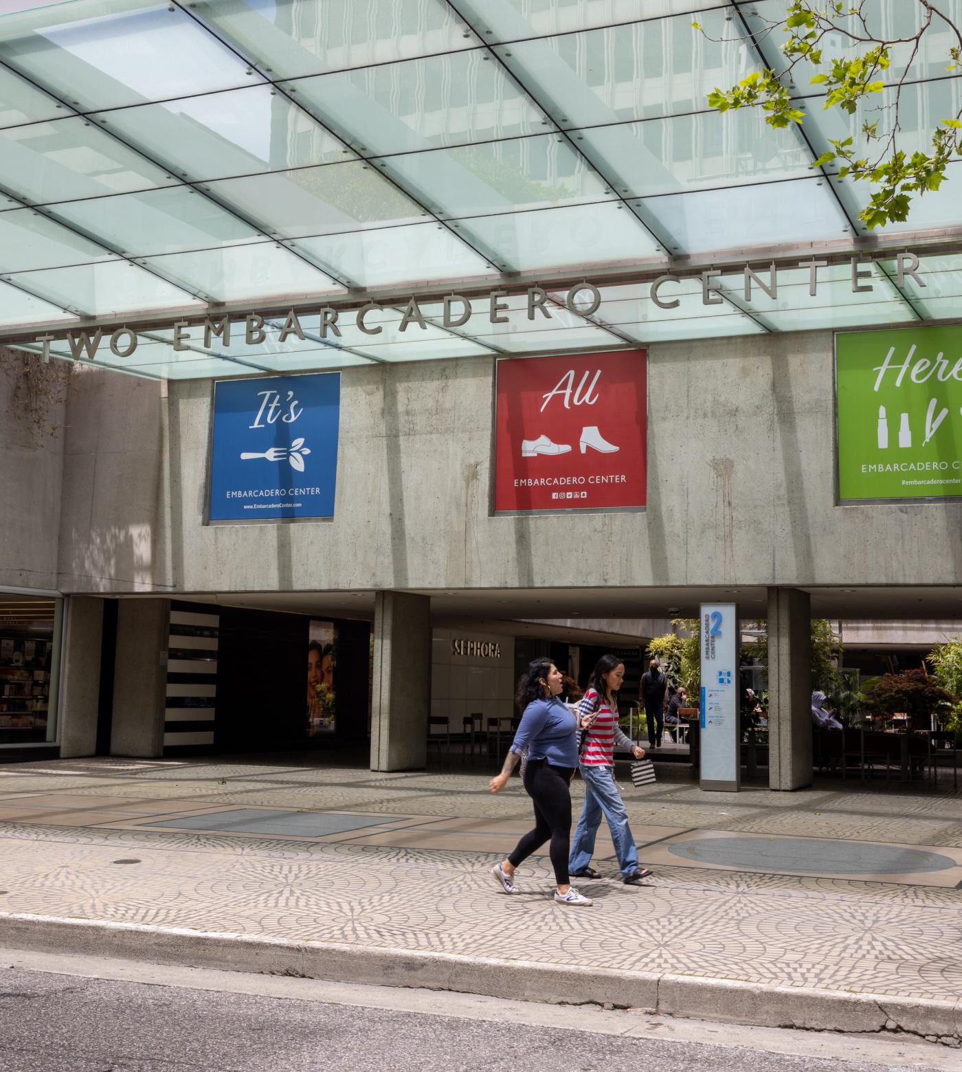 Two women walking down the street outside Two Embarcadero Center building.