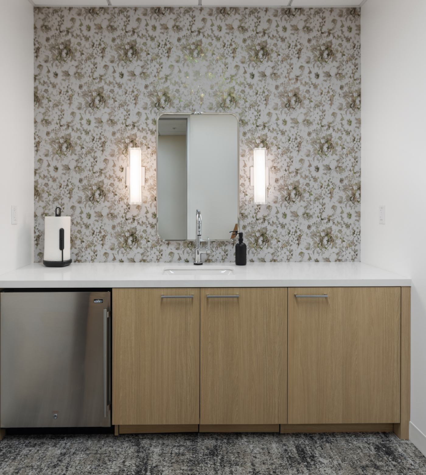 Interior view of mothers room counter, sink, refrigerator, and cupboards.